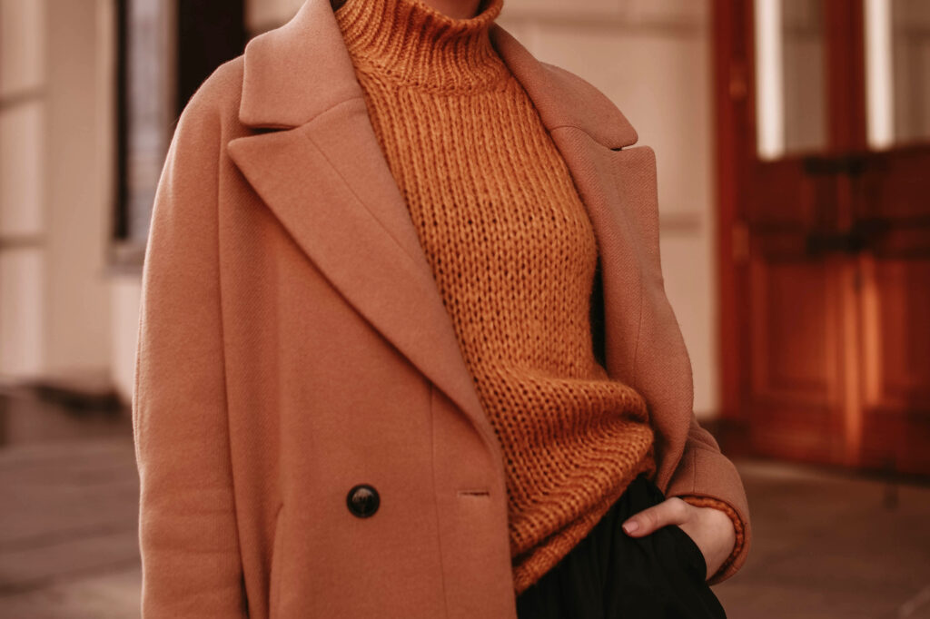 woman wearing knitted cozy sweater and brown coat